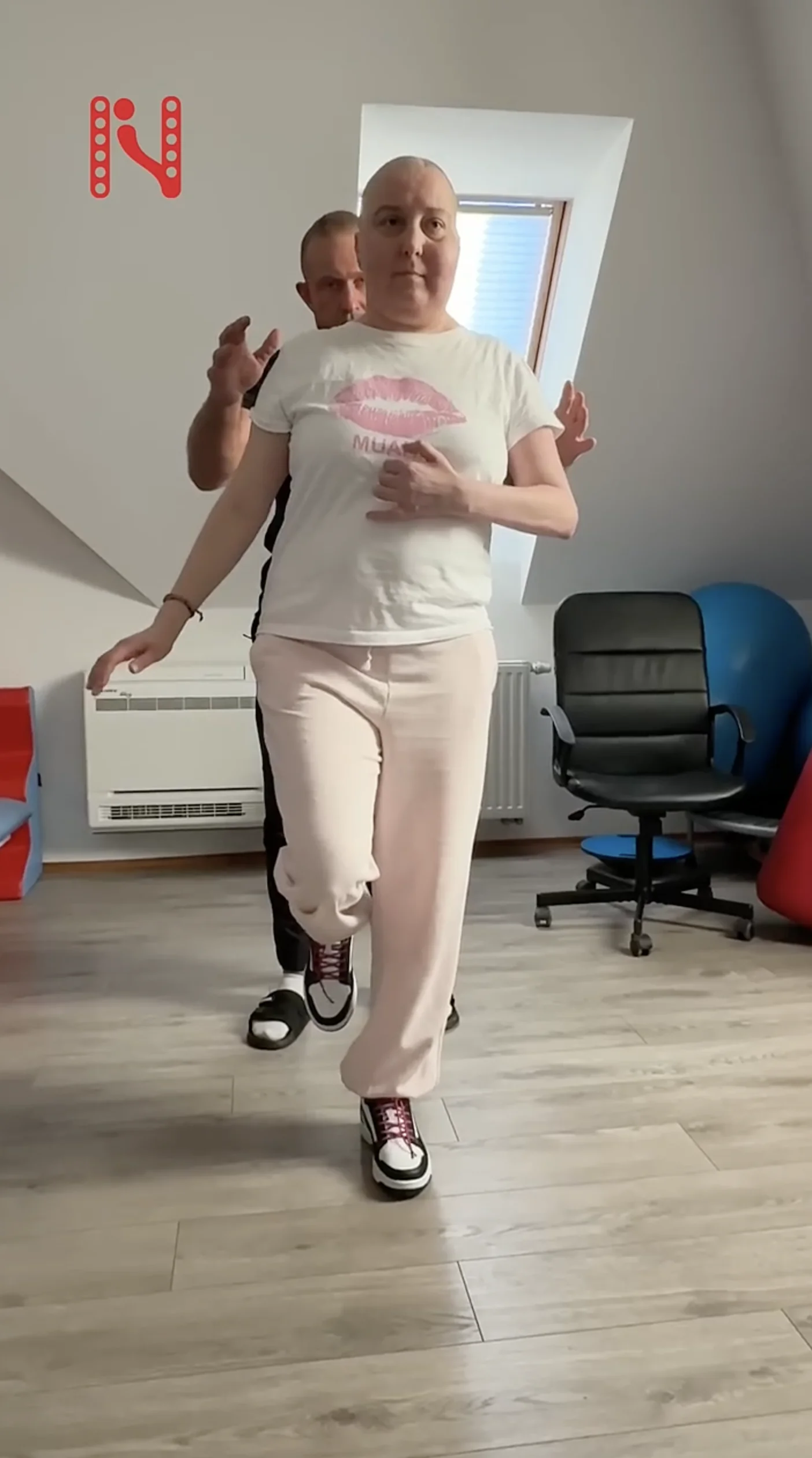 Pacjentka ćwiczy chód po operacji guza mózgu z terapeutą w Ośrodku Norman